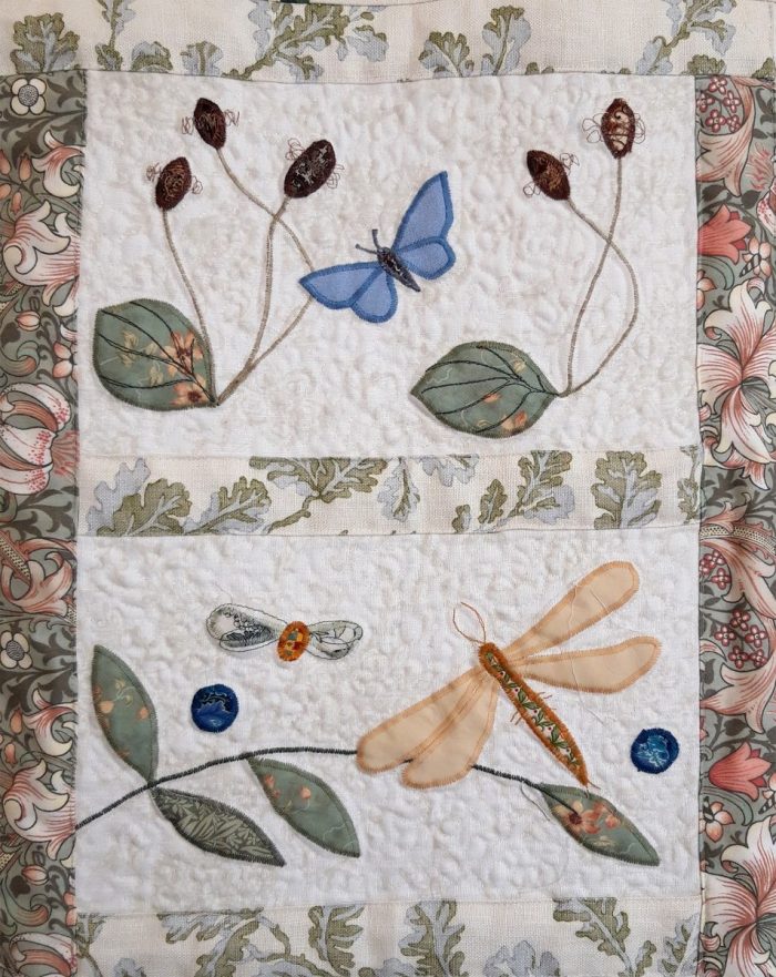 Floral Block quilt in pale greens, blues and pinks with dragonfly