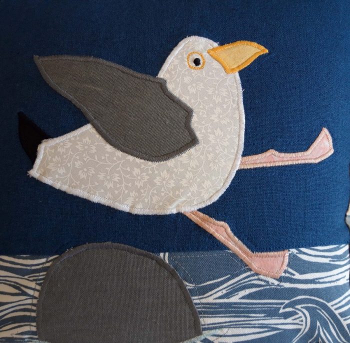 Seaside Seagull 'Oops' cushion. Linen and cotton ground with appliqué, blue and grey striped border and grey back.
