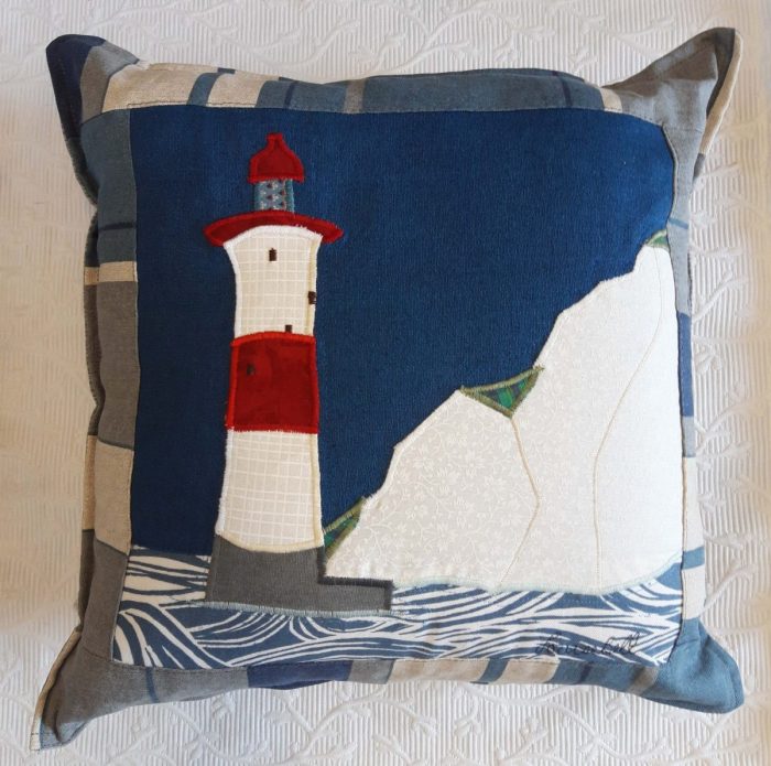 Seaside Lighthouse cushion. Linen and cotton ground with appliqué, blue and grey striped border and grey back.