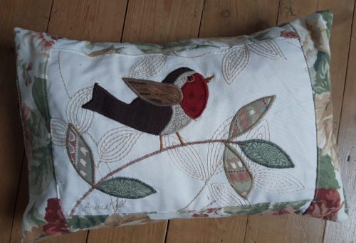 Robin on a branch facing right cushion