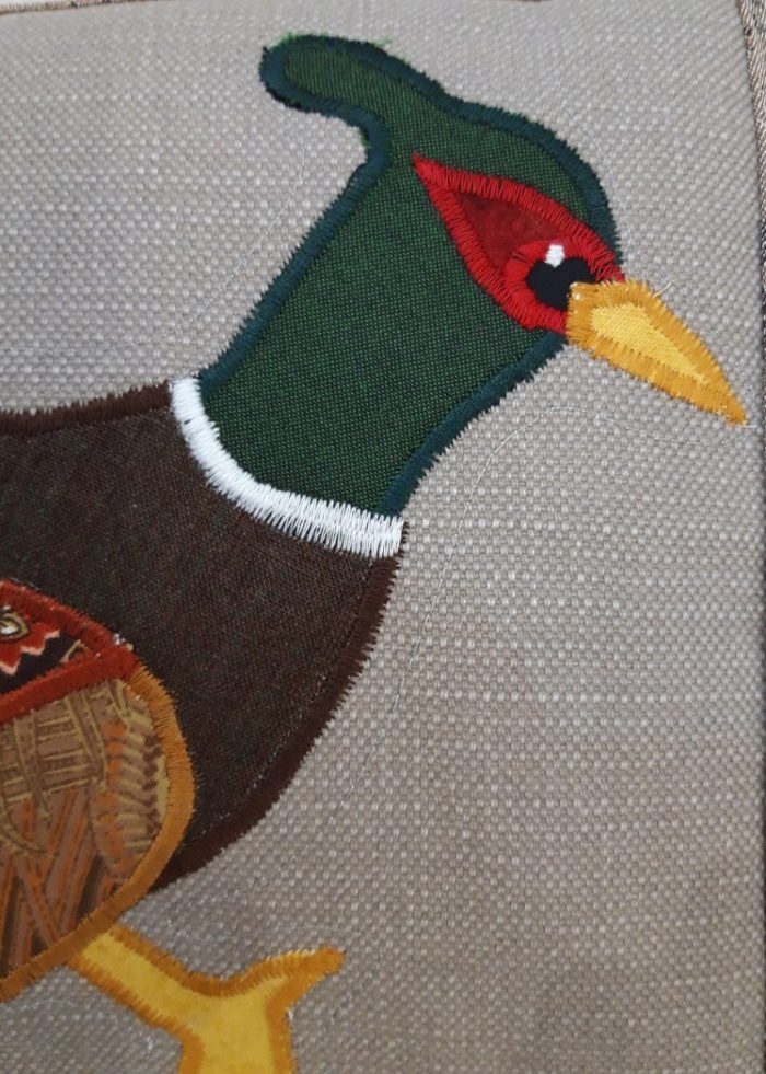 Pheasant running right cushion. Brown leaf fabric border, and back.