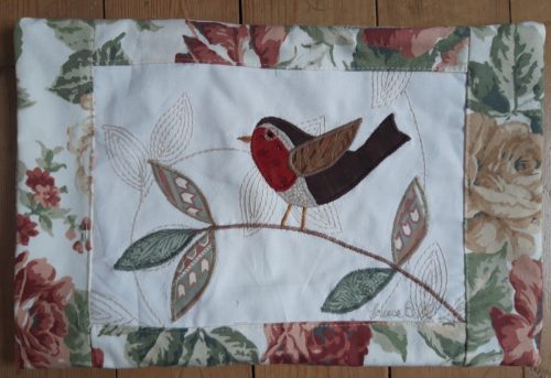 Robin on a branch facing left cushion